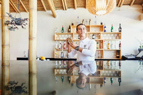 a man standing behind a counter at a bar at La Crique Nature & Spa in Dakhla