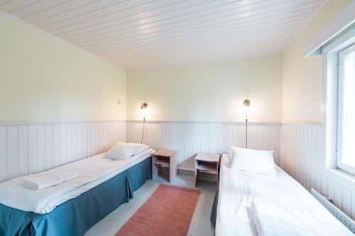 a room with two beds and a table and a window at Hotelli Messilä in Lahti