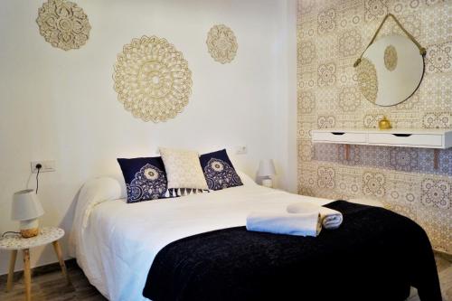 1 dormitorio con 1 cama blanca grande con almohadas azules en Apartamento Mihrab, excelente ubicacion en casco historico, en Córdoba