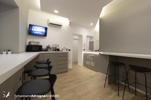 a bar with stools in a kitchen with a counter at Le Dimore Degli Archi Catania in Catania