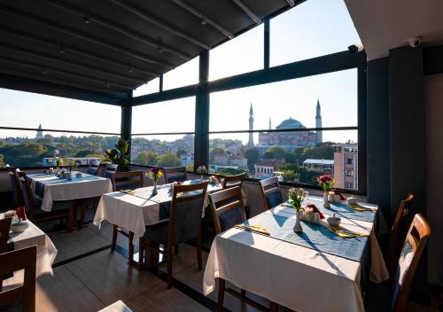 a restaurant with tables and chairs and a view of the city at Antusa Design Hotel & Spa in Istanbul