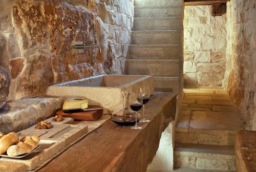 Baño de piedra con lavabo y copas de vino en Via Paradiso 32, en Feltre