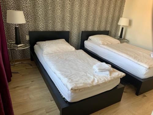 two beds in a hotel room withskirts at Apartman Skupovka in Most