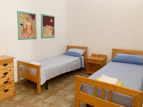 a bedroom with two beds and a dresser and two tables at Villa Bianca Kunstmann in Orosei