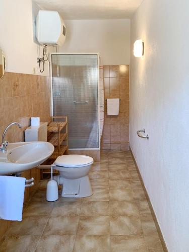 a bathroom with a toilet and a sink and a shower at Villa Bianca Kunstmann in Orosei