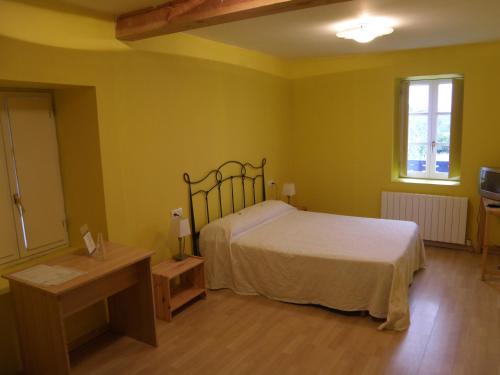 a bedroom with a bed and a table and a window at Casa Rural Ortulane in Urduliz