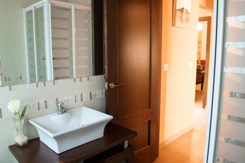 a bathroom with a white sink and a mirror at Casa con piscina de agua salada Villa Pepucho 1 in Córdoba