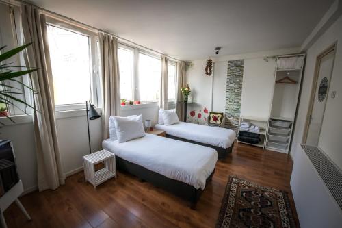 a bedroom with two beds and a window at City Break Amsterdam in Amsterdam