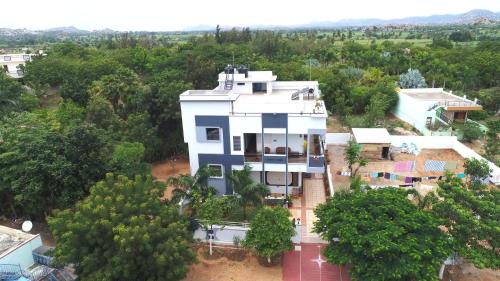 an aerial view of a white house with trees at Arjun Homestay in Hampi