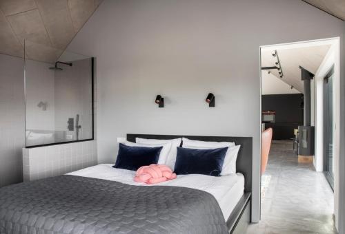 a bedroom with a bed with a pink pillow on it at Luxury house, Golden Circle getaway - Private hot tub and sauna in Reykholt