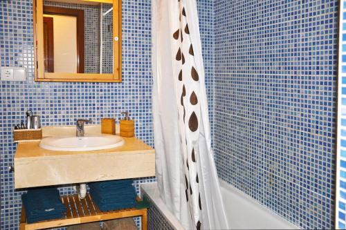 ein blau gefliestes Bad mit einem Waschbecken und einer Dusche in der Unterkunft Casa Lucía in Vecindario