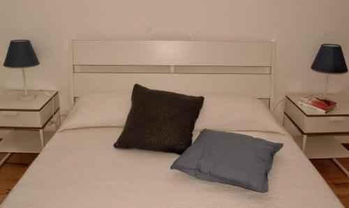 a bed with two pillows on it with two night stands at Ypsibloom in Castelbuono