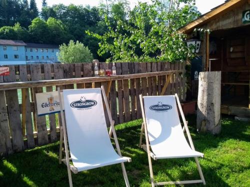 two chairs sitting in the grass next to a fence at Cafe Pension Rafaela in Steinbach an der Steyr