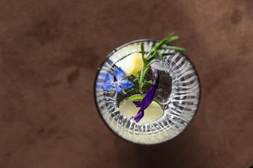 a glass vase with a purple flower in it at Hotel VIKTORIAS HOME Kufstein in Kufstein