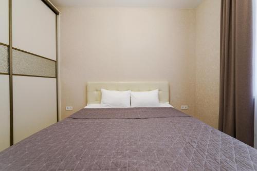 sypialnia z dużym łóżkiem i fioletowym kocem w obiekcie Apartments on Krasnaya Street w Mińsku