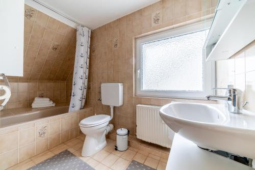 łazienka z umywalką, toaletą i oknem w obiekcie Privatzimmer mit eigenem Bad w mieście Pattensen