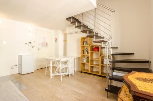 a living room with a spiral staircase and a table at Appartamento del Nettuno in Bologna