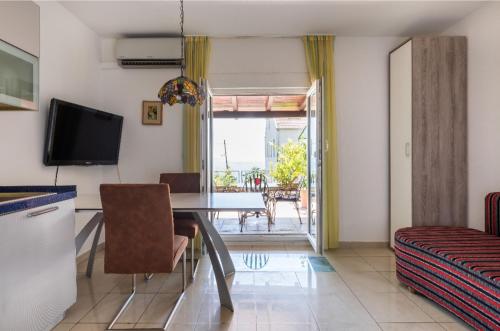a living room with a dining room table and a television at Marjan Hill in Split