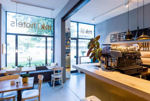 a restaurant with a counter and a table and chairs at mk hotel münchen max-weber-platz in Munich