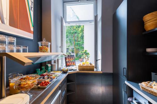 a kitchen with a counter with food on it at mk hotel münchen max-weber-platz in Munich