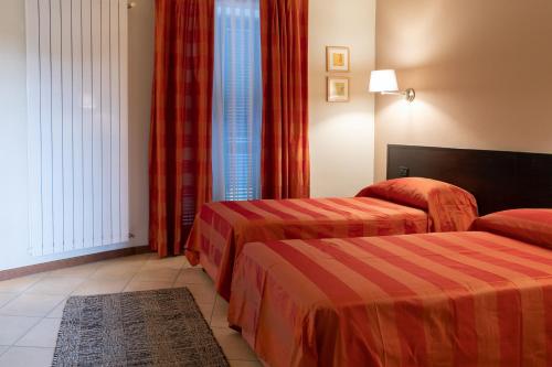 a hotel room with two beds and a window at HOTEL DEL CORSO in Borgomanero