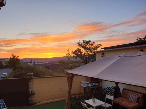 a sunset on the roof of a house with an umbrella at Sleeping Sarria in Sarria