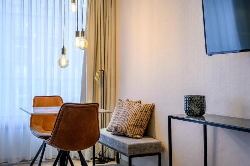 a room with two chairs and a table and a desk at PREMIER SUITES Antwerp in Antwerp