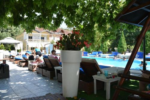 a group of people sitting in chairs near a pool at Krikonis Hotel in Ioannina