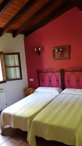奧尼斯的住宿－Casa rural el campu，卧室设有两张床铺和红色的墙壁