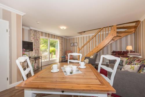 a living room with a wooden table and chairs at Appartement Am Park der Sinne & Am See in Binz