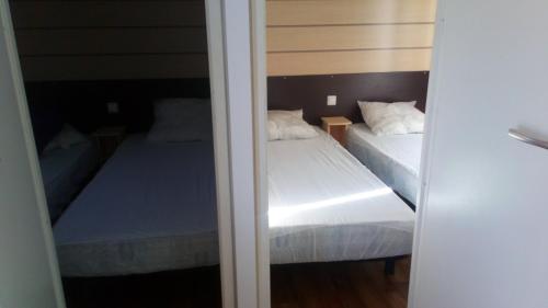 - 2 lits dans une petite chambre avec 2 lits dans l'établissement Au coeur des collines gersoise. Cottage confort, à Saramon