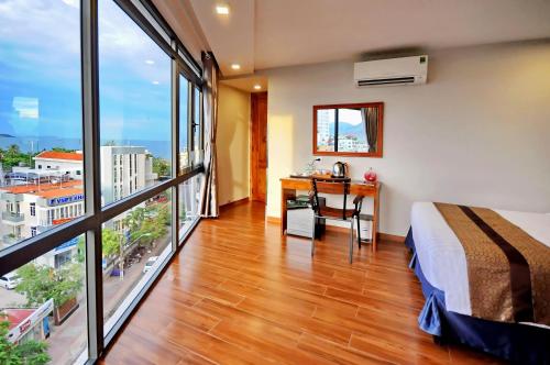 ニャチャンにあるCKD Nha Trang hotelのベッドルーム1室(ベッド1台、窓のあるデスク付)