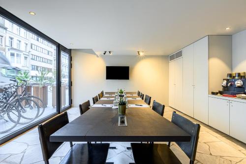 a conference room with a long table and chairs at PREMIER SUITES Antwerp in Antwerp