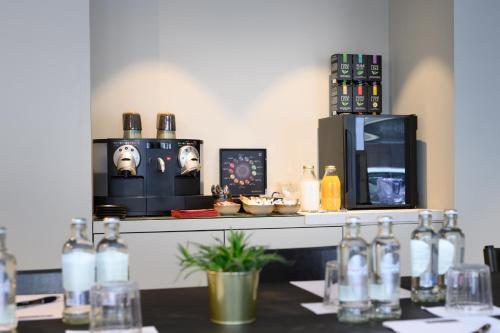 a table with wine bottles on a counter with a microwave at PREMIER SUITES Antwerp in Antwerp