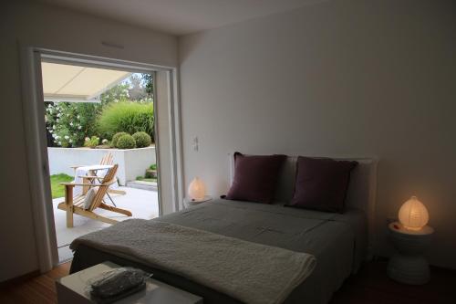 una camera da letto con un letto e una porta scorrevole in vetro di VILLA GOLFE AJACCIO près des plages ad Ajaccio