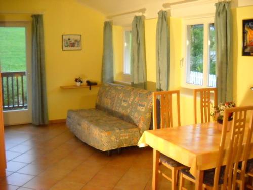 a living room with a couch and a table at Appartments Am Wiesenrand in Nova Ponente