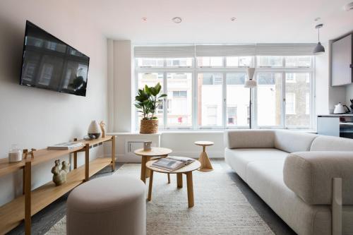 a living room with a couch and a table at Hausd - Leicester Square in London