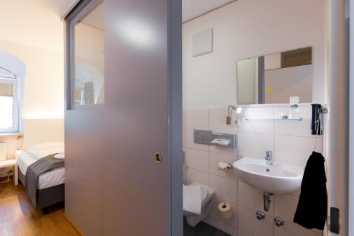 a bathroom with a sink and a mirror at mk hotel münchen max-weber-platz in Munich