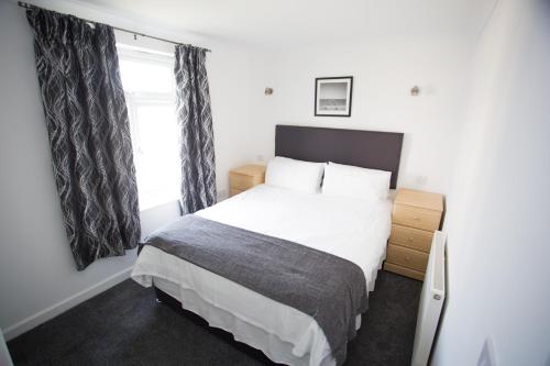 a small bedroom with a bed and a window at Atlantic Reach Resort in Newquay