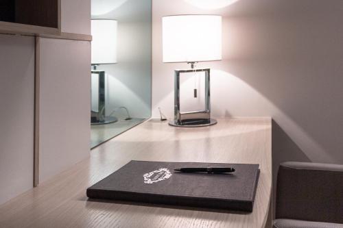 Lampa na stole z notatnikiem w obiekcie Harry's Bar Trevi Luxury Apartments - Modelli w Rzymie