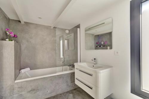 La salle de bains est pourvue d'une baignoire, d'un lavabo et d'une baignoire. dans l'établissement La Dependance by Cocoonr, à Bordeaux