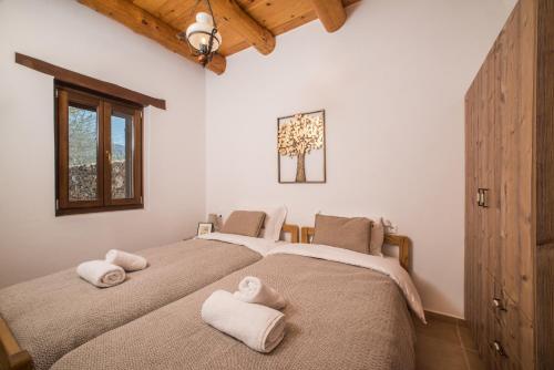 2 łóżka w sypialni z ręcznikami w obiekcie ARADENA TRADITIONAL House 4 w mieście Arádhaina
