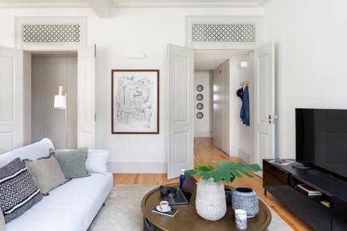 a living room with a white couch and a tv at ALTIDO Downtown Bliss Apartments in Lisbon