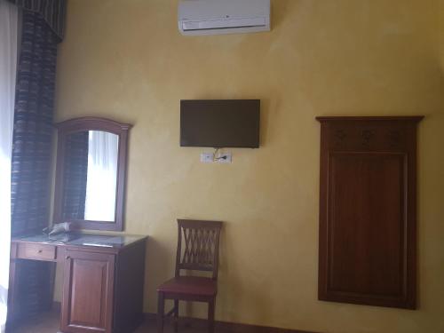 ローマにあるPitagora Houseのデスク、壁掛けテレビが備わる客室です。