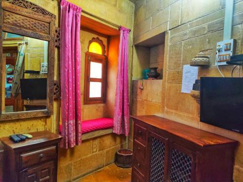 um quarto com um banco vermelho e um espelho em Shahi Palace Hotel Jaisalmer em Jaisalmer