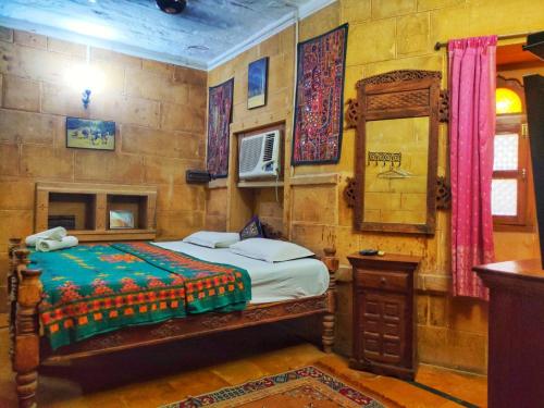 um quarto com uma cama e um espelho em Shahi Palace Hotel Jaisalmer em Jaisalmer
