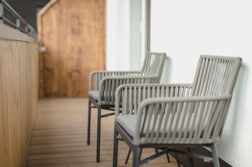 three chairs sitting in a hallway with a door at Hotel Schwarzer Adler - Sport & Spa in Sankt Anton am Arlberg