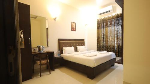 sypialnia z łóżkiem, biurkiem i lustrem w obiekcie Kkainaat Hotel w mieście Amritsar
