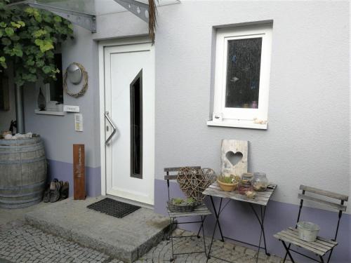 a door of a house with a table and a window at Haus Bienen in Ihringen