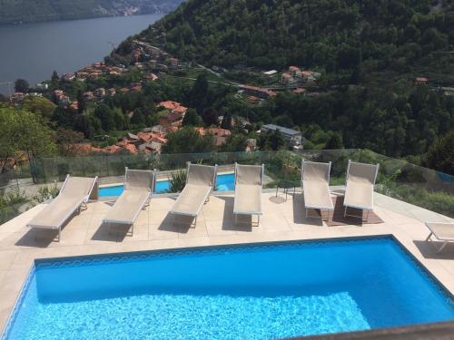 a pool with chairs and a view of a mountain at Villa Lilla in Argegno